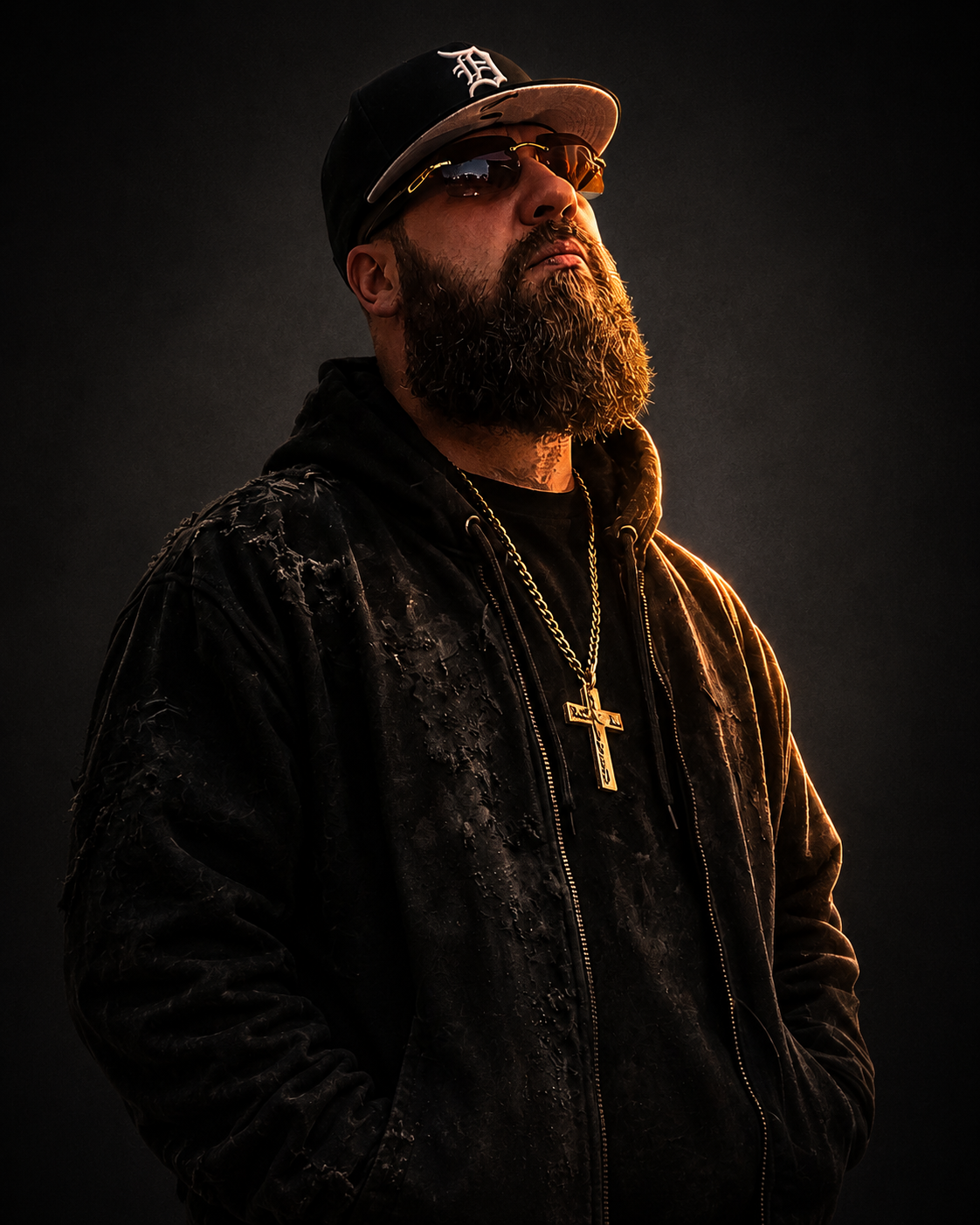 Christian J. wearing a Detroit cap, dark jacket, sunglasses and cross necklace